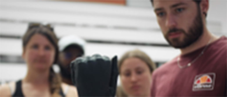 Drei Studierende schauen auf Prothesenhand