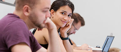 Studentin an Vorlesung schaut in Kamera