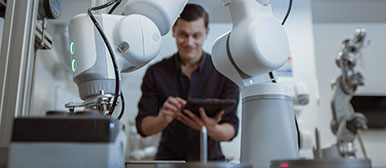 Mann arbeitet mit Roboterarm