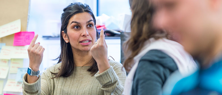 Foto zeigt eine Studentin, die in der Klasse ihren Prototyp erklärt.