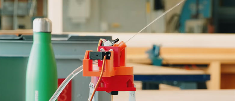 Kleiner Feuer-Löschturm mit Schläuchen und Sensoren in einem technischen Laboraufbau auf einer Werkbank