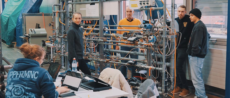 Eine Gruppe junger Studierender arbeitet an einem Modell