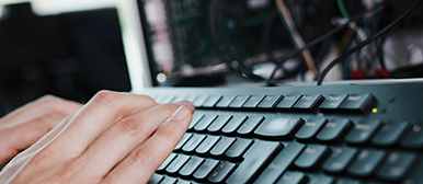 Zwei Hände, die auf einer schwarzen Tastatur herumtippen aus der Nähe 