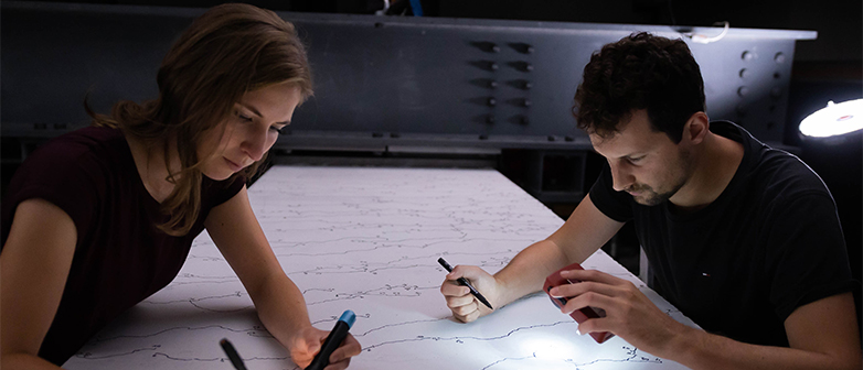 Zwei Studierende arbeiten an Skizzen