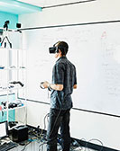 Ein Mann mit VR Brille schaut in den Raum um sich