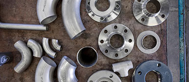 Rohrteile und Verbindungsstücke aus Stahl auf einem Tisch angeordnet