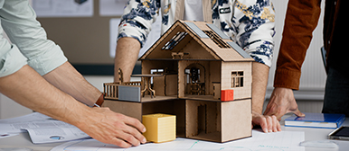 Ein Modell-Haus, das von drei Personen , die ab der Brust abgeschnitten sind, begutachtet wird