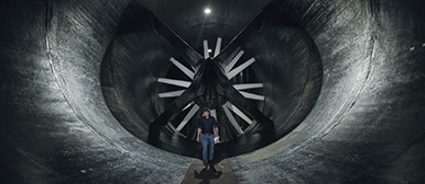 Ein Mann steht mitten in einem dunklen Windkanal 