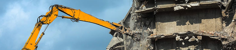 Bagger beim Einreissen einer Hausfassade