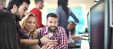 zwei maenner und eine frau sitzen vor einem computer