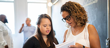 Zwei Frauen schauen auf ein Blatt Papier