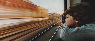 Kind schaut aus fahrendem Zugfenster