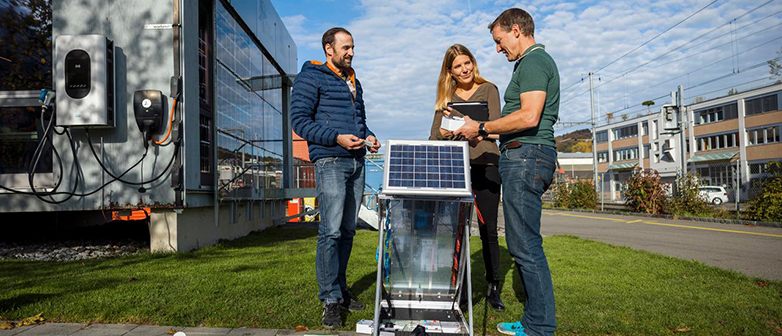 Drei Menschen an einem Solarpanel