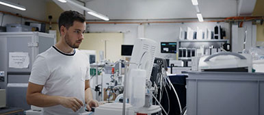 Ein Mann arbeitet mit medizintechnischen Geräten und kontrolliert etwas auf einem Display.