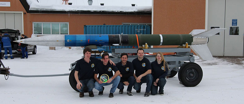 Mitglieder des CEMIOS-Team posieren vor der Rakete.