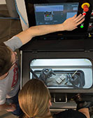 Zwei Studierende prüfen ein elektronisches Gerät in der Werkstatt