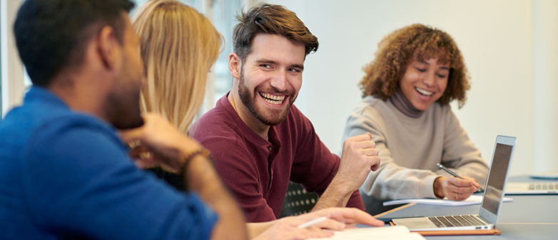 Vier Studierende am Tisch mit Laptop