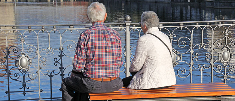 zwei Senioren sitzen auf einer Bank