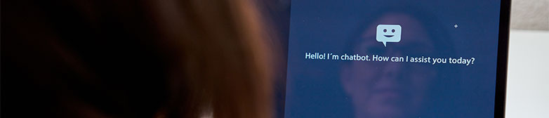 Person sitzt vor Laptop und benuetzt generative KI Anwendung