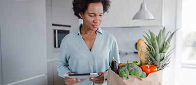 Frau prueft ihre Einkäufe mittel Tablet