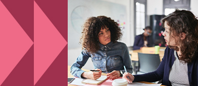 Zwei Fachpersonen führen ein konzentriertes Gespräch an einem Tisch mit Notizen – Symbolbild für interne Kommunikation, Change-Prozesse und vertrauensvolle Dialogkultur in Organisationen.