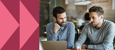 Zwei Fachpersonen diskutieren konzentriert vor einem Laptop in einem Büroraum – Symbolbild für strategische Unternehmenskommunikation, professionelle Beratung und gemeinsame Entscheidungsfindung.