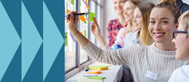 Gruppe von jungen Erwachsenen , die gemeinsam mit bunten Haftnotizen und Markern Ideen festhalten; kreative Teamarbeit und Brainstorming