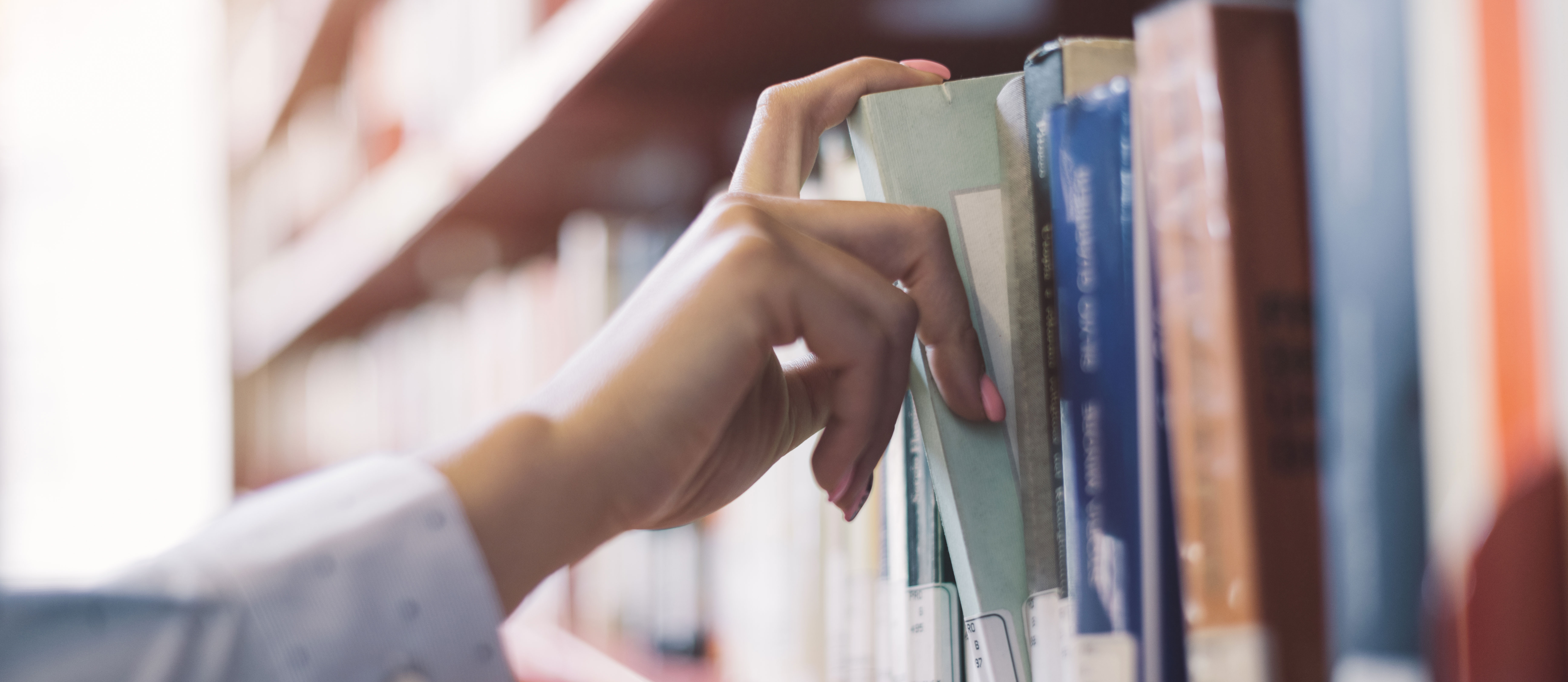 Buch wird aus einem Bücherregal genommen