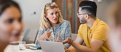 Frau und Mann vor Laptop im Gespräch