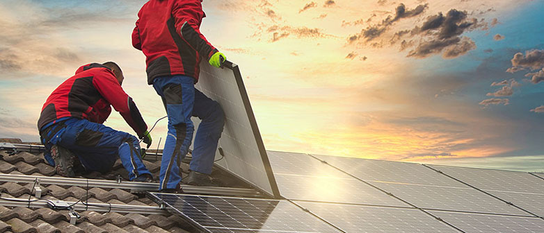 Bauarbeiter auf einem Dach mit Solarpanels