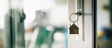 Schlüssel steckt im Schlüsselloch einer Glastür