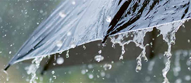 Wasser perlt von Regenschirm ab