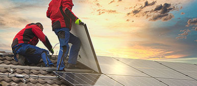 Bauarbeiter mit Solarpanels auf einem Dach