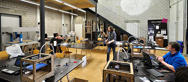 Bild vom FabLab mit Menschen an Arbeitstischen