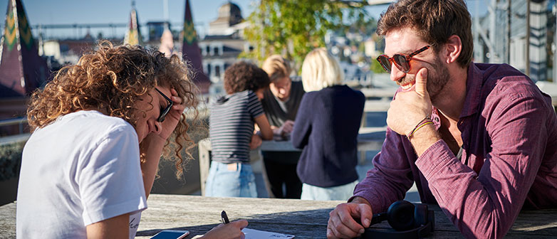 Studierende im Gespräch auf einer Dachterrasse