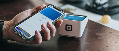 Eine Hand hält das Handy an ein Lesegerät