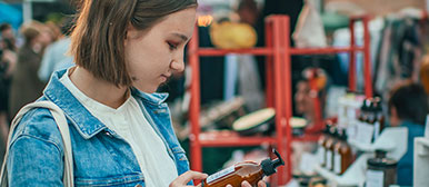 Frau beim Einkaufen mit einem Handy in der Hand