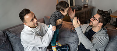 Zwei Männer und ein Kind auf dem Sofa