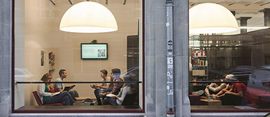 Aussensicht durch ein Fenster auf eine Gruppe Menschen