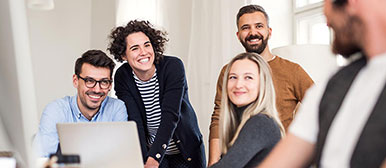 Menschen mit Laptop am Tisch im Gespräch