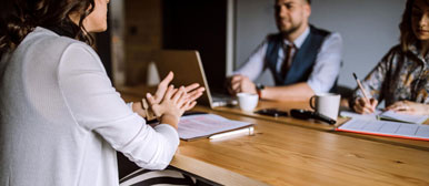 Personen mit Laptop an einem Schreibtisch
