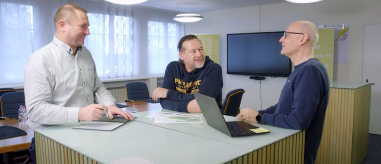 Drei Mitarbeiter stehen arbeitend an einem Tresen