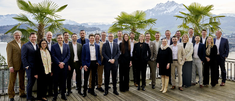 Diplomklasse EMBA auf Terrasse mit Hintergrund Palmen und Pilatus